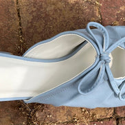 Light blue double bow peep hole sandal with low heel and slip-on design. Vegan leather with DreamCloud cushion.