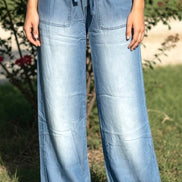 Light blue chambray pants from 42POPS showing a relaxed fit, paper bag waist and front pockets.
