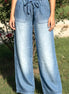 Light blue chambray pants from 42POPS showing a relaxed fit, paper bag waist and front pockets.