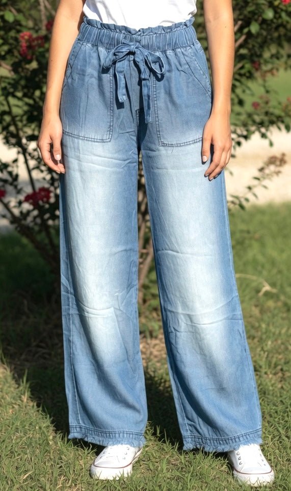 Light blue chambray pants from 42POPS showing a relaxed fit, paper bag waist and front pockets.