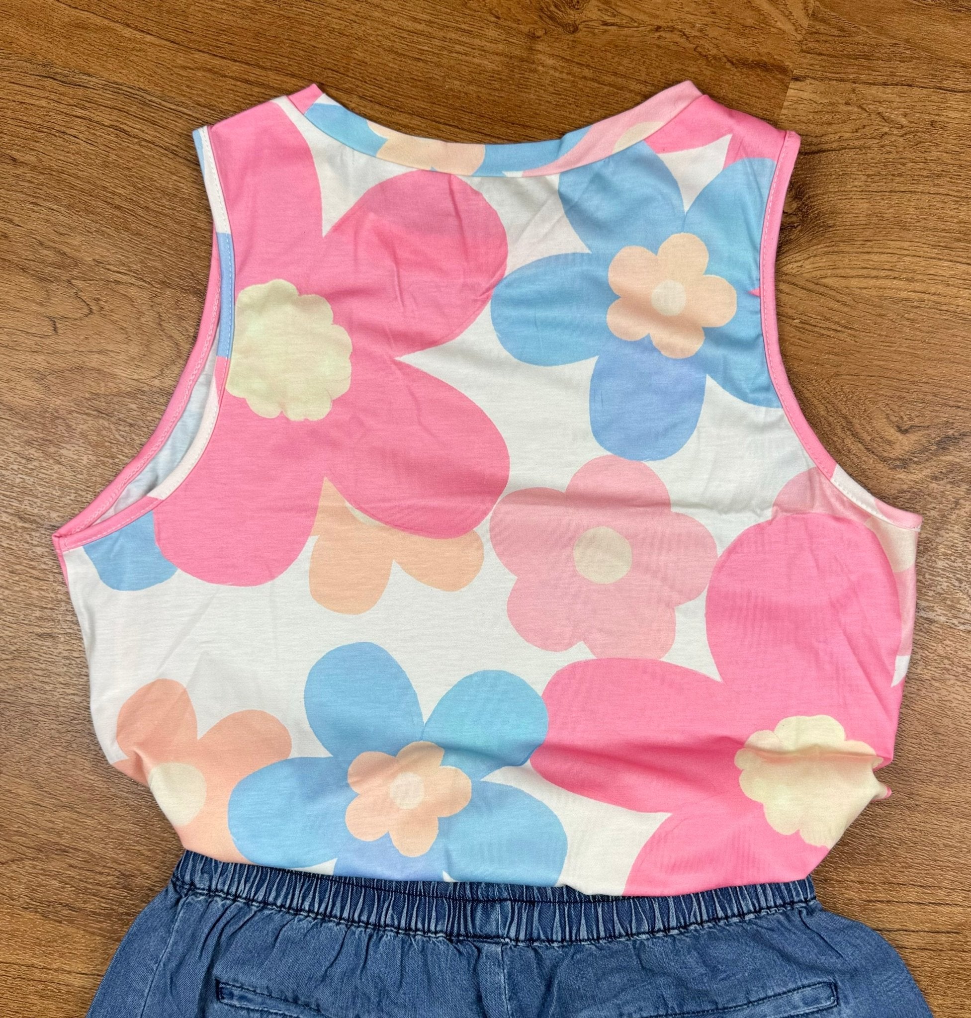 Pink floral print tank top by Aapparella, featuring a sleeveless design and vibrant flower pattern on lightweight fabric.