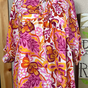 ADORA LA peasant floral top with billowy sleeves and a v-neck, featuring colorful floral patterns and lightweight fabric.
