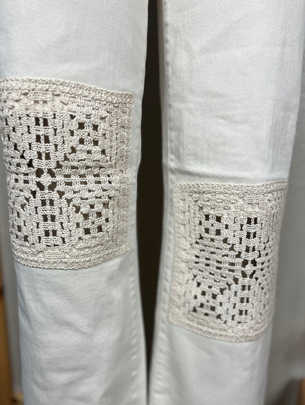 Judy Blue Ecru Crocheted Patches denim jeans showing detailed stitched patches and distressed fabric on the thigh area.