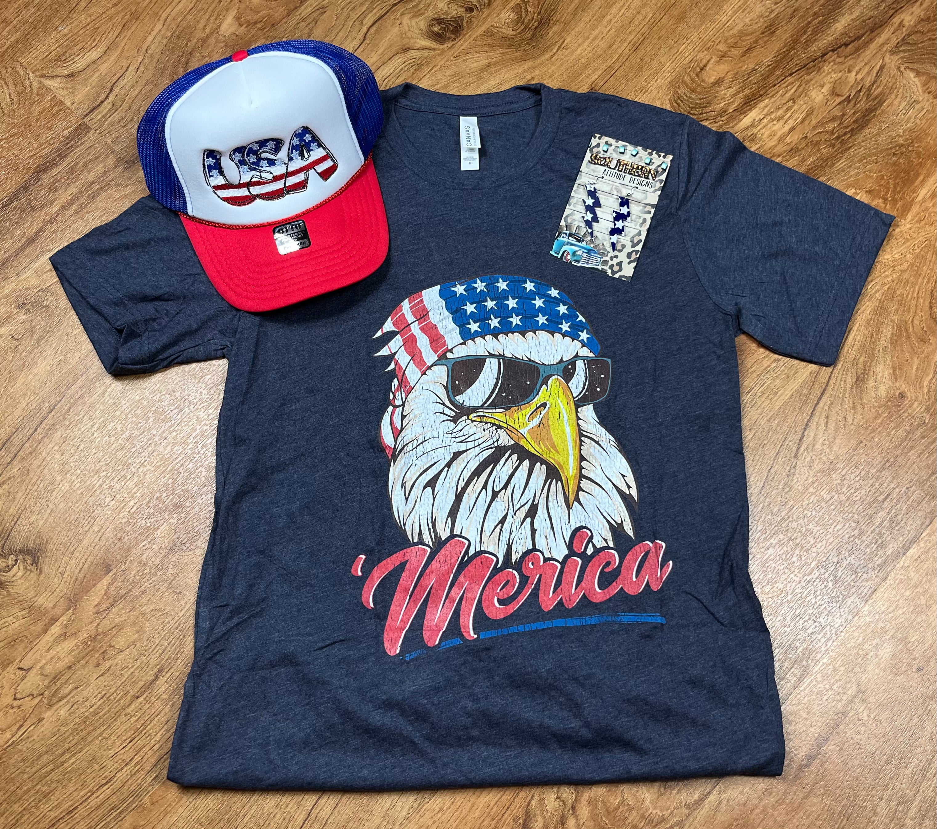 Front view of a patriotic T-shirt by Southern Attitude Designs Inc, featuring red, white, and blue American flag-inspired graphics.