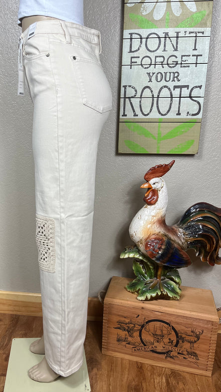 Judy Blue ecru jeans with crocheted patches, showcasing detailed beige and white crochet designs on denim fabric.