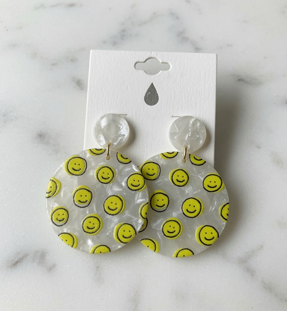 Avenue Zoe Happy Face Dangles earrings featuring cheerful smiling face charms on gold-tone hooks.