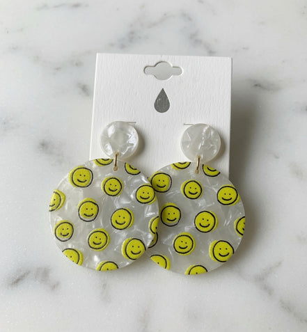 Avenue Zoe Happy Face Dangles earrings featuring cheerful smiling face charms on gold-tone hooks.