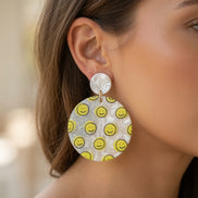 Avenue Zoe Happy Face Dangles earrings with cheerful face design and gold-tone hooks on a white background