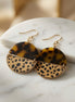 Avenue Zoe tortoise and cheetah print dangle earrings with gold hooks, showcasing a stylish animal print design.