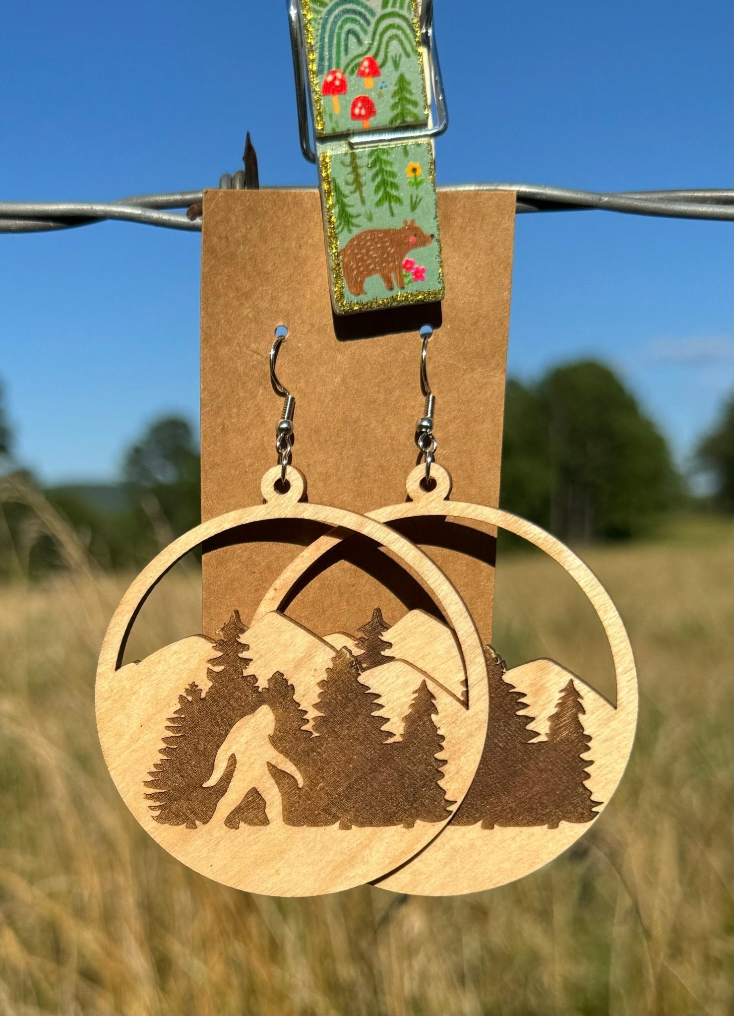 Bigfoot wooden earrings by Krafty Supply featuring carved woodland creature design on natural wood.