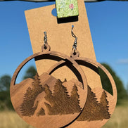 Wooden Bigfoot earrings by Krafty Supply featuring carved Sasquatch designs on natural wood dangle earrings.