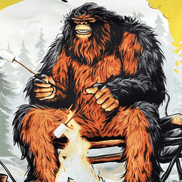 Squatchin’ Country Bigfoot roasting marshmallows graphic T-shirt, casual outdoor wear featuring a Bigfoot silhouette with marshmallow roasting scene.