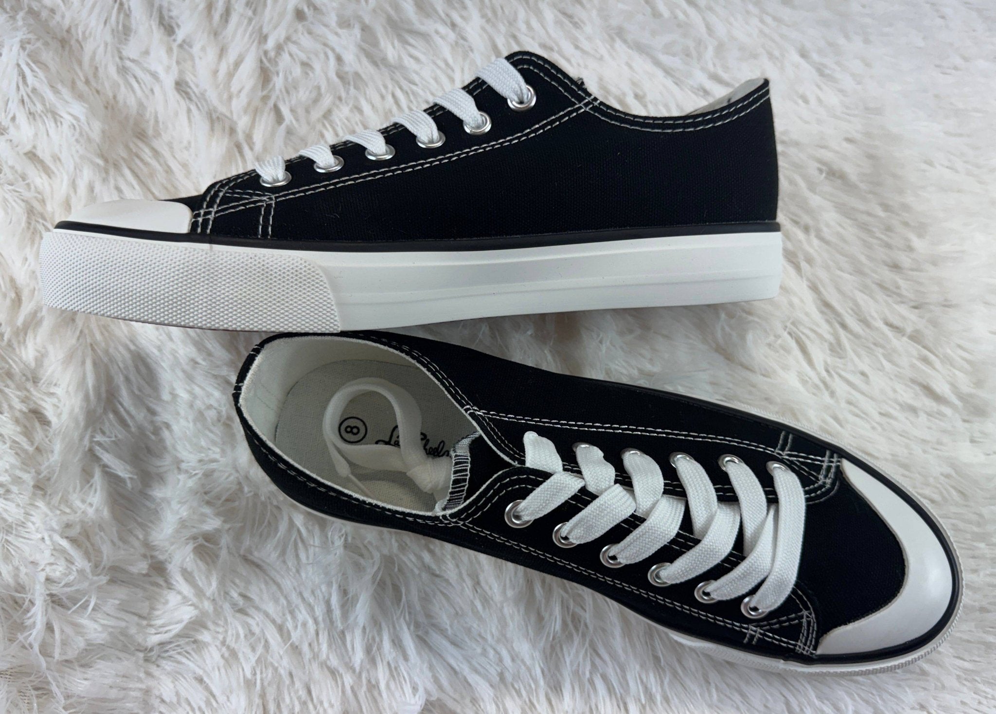 FASHION EMPORIO classic black sneakers showing a sleek, low-top design with white rubber soles and stylish laces.