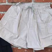 Khaki wide leg cargo shorts from ADORA LA displayed on a model, featuring multiple pockets and a relaxed fit for casual wear.