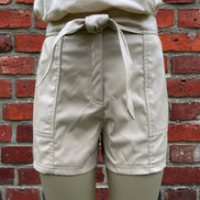 Black faux leather shorts by And The Why, featuring a high-waisted design and sleek, shiny finish.