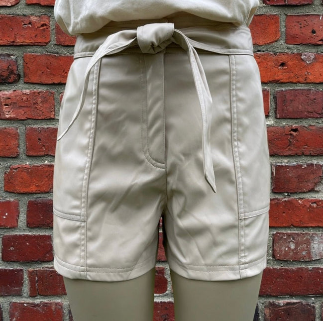Black faux leather shorts by And The Why, featuring a high-waisted design and sleek, shiny finish.