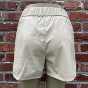 Black faux leather shorts by And The Why, featuring a high-waist design and sleek fit, shown on a neutral background.
