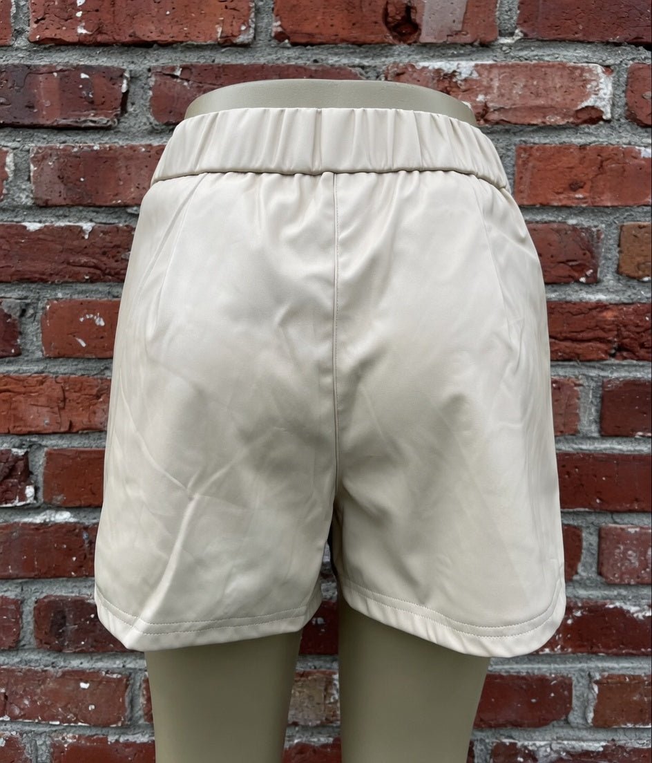 Black faux leather shorts by And The Why, featuring a high-waist design and sleek fit, shown on a neutral background.