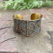 Rustic blue patina brass cuff bracelet with peace sign design by Anju Jewelry, featuring a textured, artisanal finish.