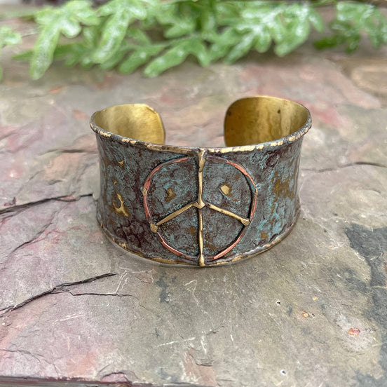 Rustic blue patina brass cuff bracelet with peace sign design by Anju Jewelry, featuring a textured, artisanal finish.