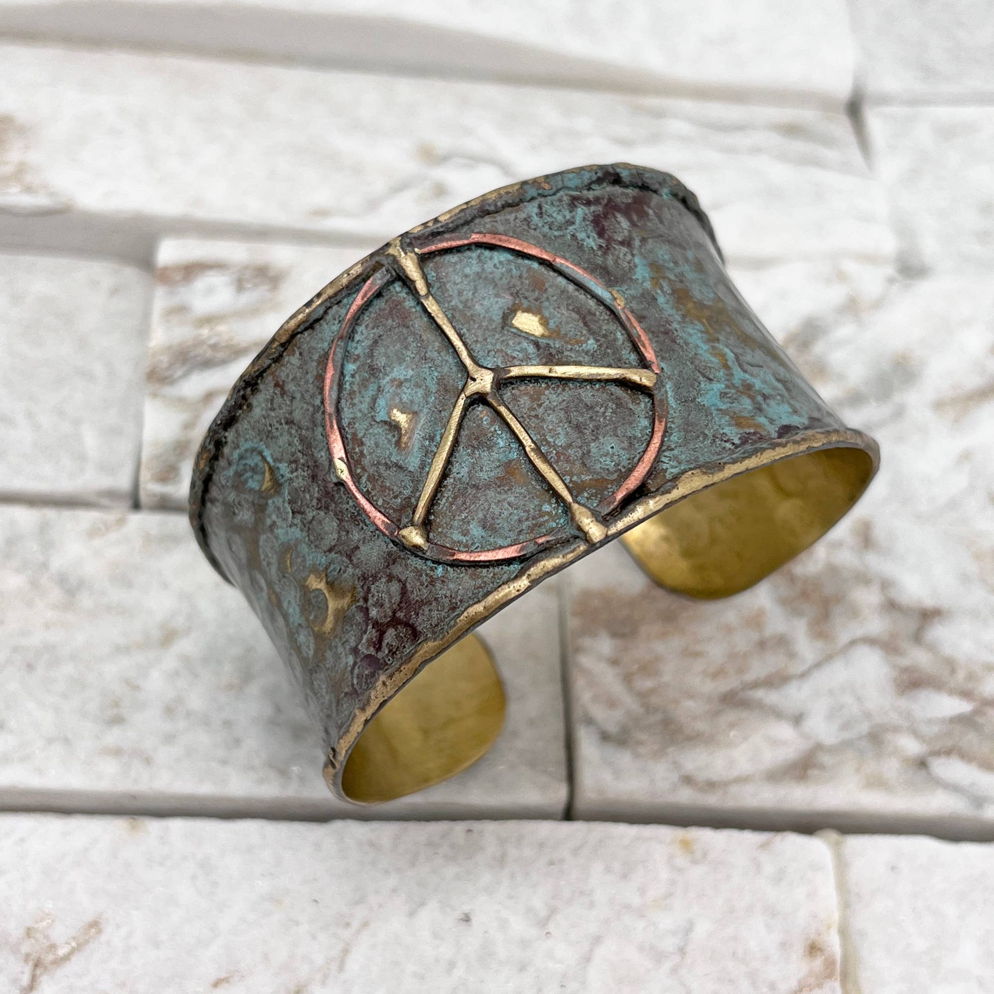 Rustic blue brass patina cuff bracelet with peace sign design by Anju Jewelry, featuring a textured, artisanal finish.