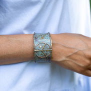 Rustic blue patina brass cuff bracelet featuring a peace sign design by Anju Jewelry