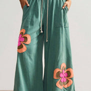 Sea green flower patched drawstring pants by FashionWorks featuring contrast elastic waistband and floral patch details.