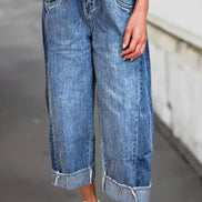 A pair of stitched raw hem wide-leg loose jeans from Aapparella featuring distressed details and relaxed fit.
