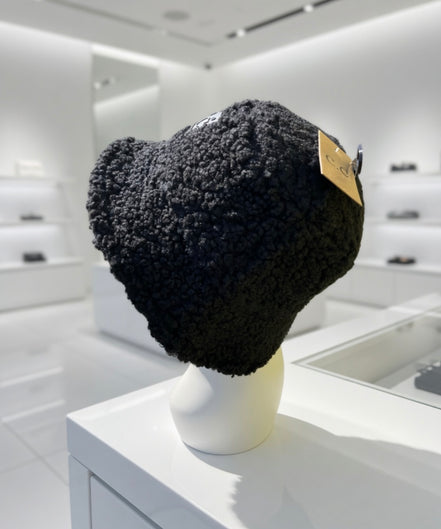 Hana C.C Rubber Patch Sherpa bucket hat with a wide brim and embroidered rubber patch, featuring cozy sherpa fabric and casual style.