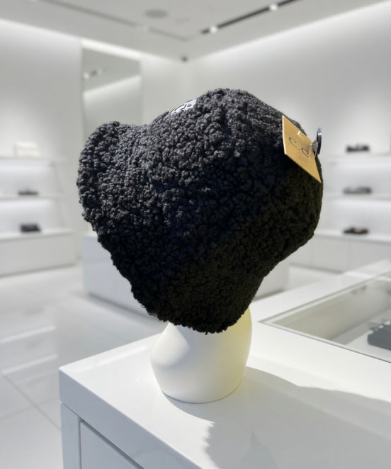 Hana C.C Rubber Patch Sherpa bucket hat with a wide brim and embroidered rubber patch, featuring cozy sherpa fabric and casual style.