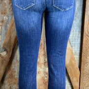 Button fly, high rise ankle, distressed with frayed hems.