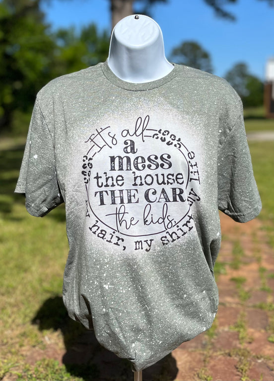White bleached cotton T-shirt from Southern Backroad Tees with "It’s all a mess" graphic print on front.