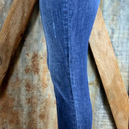 Button fly, high rise ankle, distressed with frayed hems.