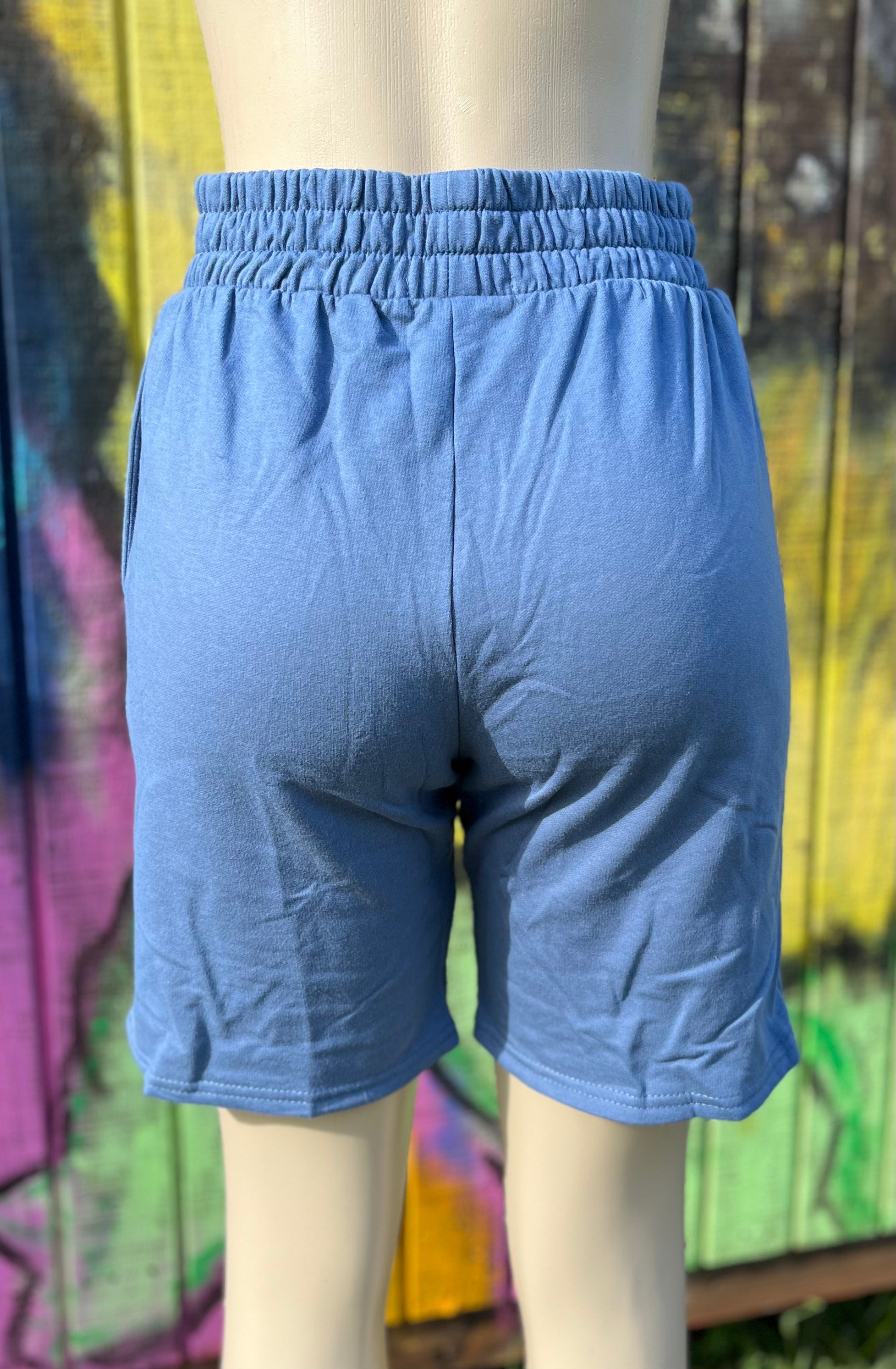 Vintage blue shorts from Vanilla Monkey with a relaxed fit, featuring a waistband and casual style, shown on a hanger.