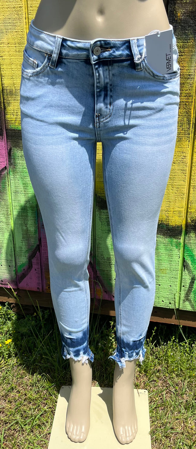 VERVET mid-rise skinny jeans in classic blue denim, featuring a close-up of fitted waist and tapered leg design.