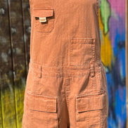 Washed cargo romper by Oli&Hali featuring a relaxed fit, multiple pockets, and casual style, displayed on a hanger.