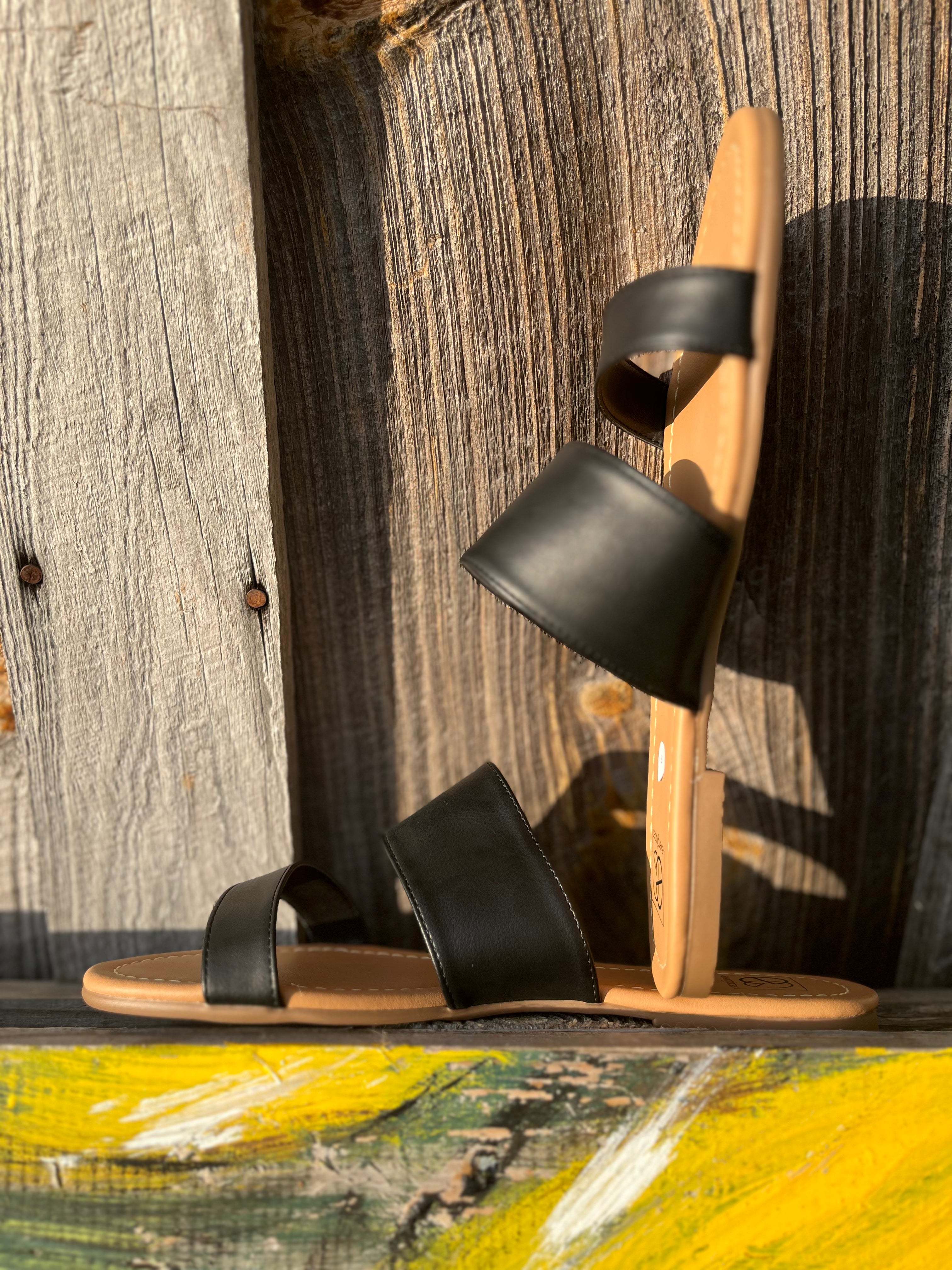 Black strap sandals from Miami Shoe featuring open toe design and ankle strap for casual summer wear.