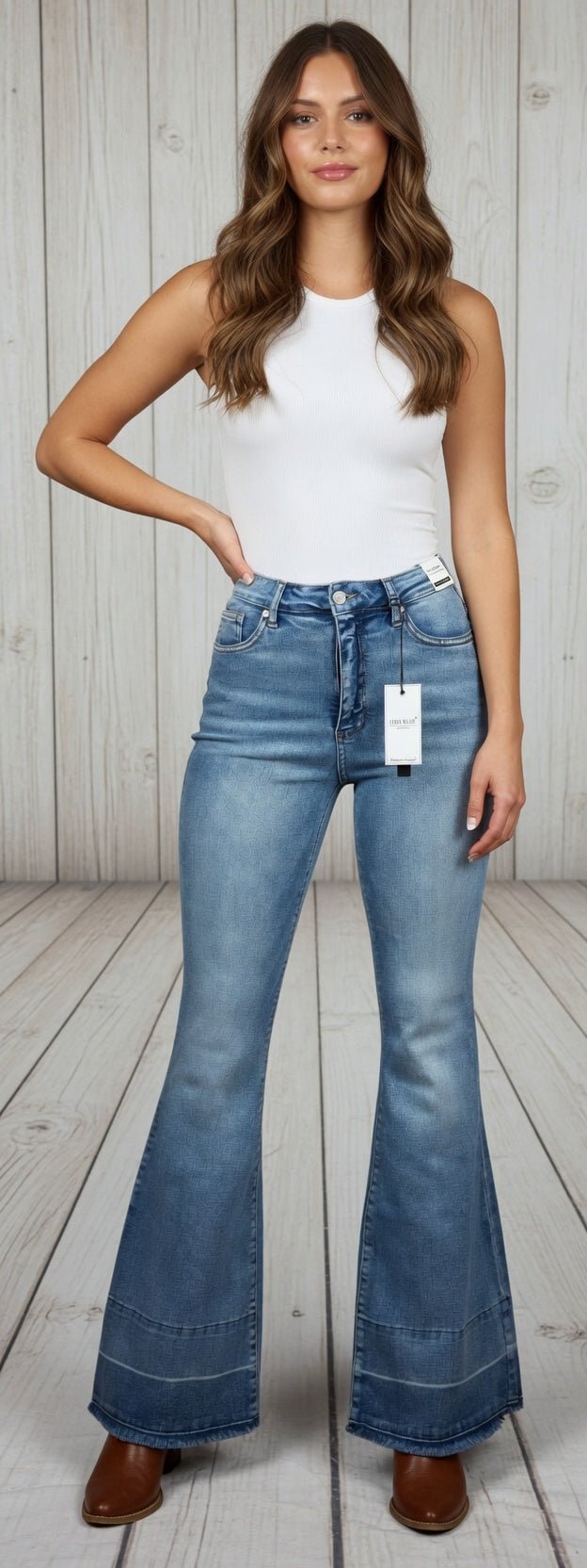 Light blue Judy Blue flare jeans with distressed details and high-waisted fit, styled with a casual top and sneakers.