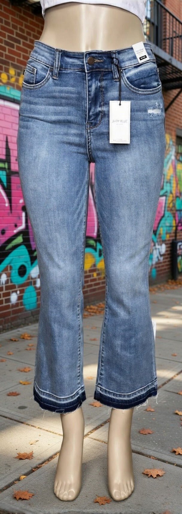 Judy Blue mid-rise release hem cropped bootcut jeans displayed on a model, showcasing the stylish cut and fit.