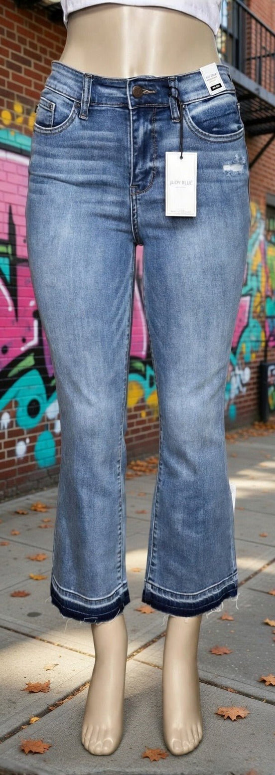 Judy Blue mid-rise release hem cropped bootcut jeans displayed on a model, showcasing the stylish cut and fit.