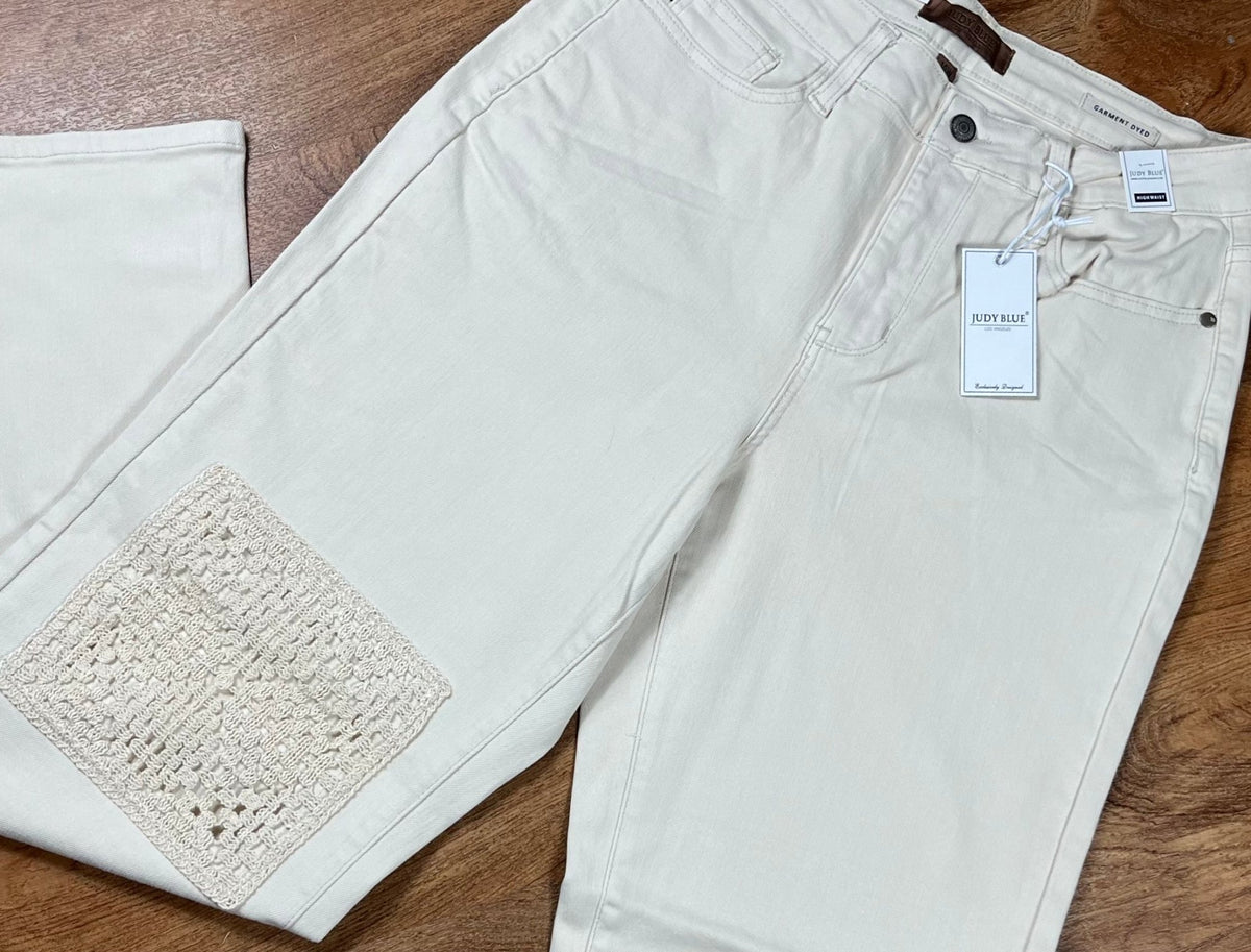 Judy Blue Ecru Plus Jeans showing fit and style, with classic five-pocket design and distressed details on light-colored denim.