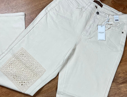 Judy Blue Ecru Plus Jeans showing fit and style, with classic five-pocket design and distressed details on light-colored denim.
