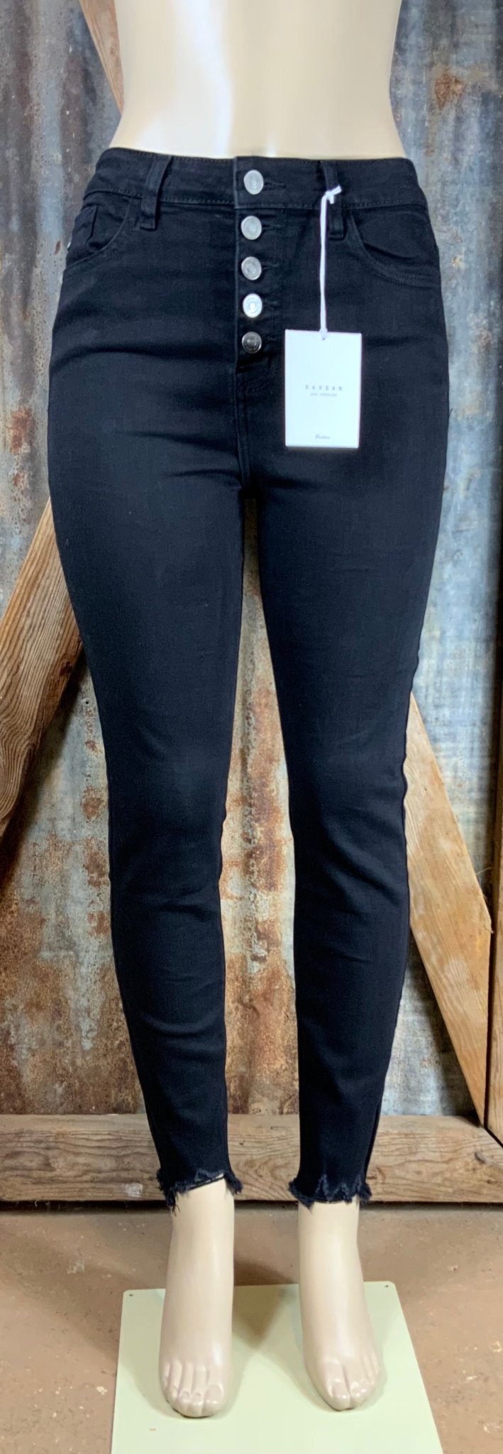 Black high-rise skinny jeans by KanCan shown on a model, featuring a fitted silhouette and classic denim texture.