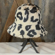 Beige and black leopard print bucket hat from La Plaza Mall, featuring a stylish wide brim and bold animal pattern.