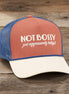 Questionables Not Bossy Trucker Hat featuring a classic mesh back and adjustable strap with bold front lettering.