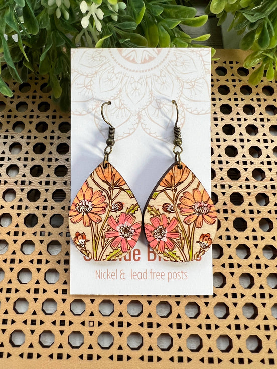 Hand-painted boho Daisy wood earrings by Seasideblooms, lightweight with floral design, hanging from silver hooks.
