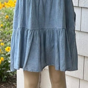 Light blue denim summer dress from Shopin La with adjustable straps and a relaxed fit, perfect for warm weather.