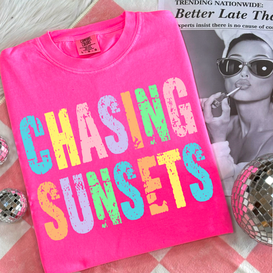 Adult neon T-shirt with "Chasing Sunsets" design by Southern Backroad Tees LLC, featuring vibrant sunset graphics.