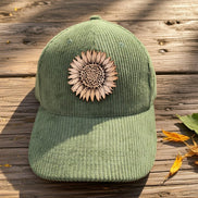 Trendy Tee Co. corduroy cap featuring a sunflower leather patch, stylish and casual accessory for everyday wear.