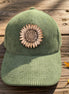 Trendy Tee Co. corduroy cap featuring a sunflower leather patch, stylish and casual accessory for everyday wear.